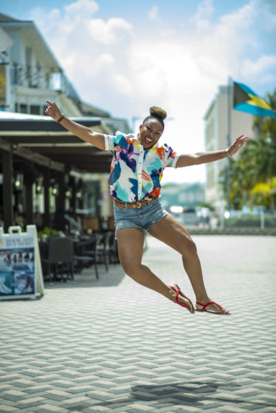 This Bahamian Gyal blogger, Rogan Smith jumps in front of the Bahamian flag in Downtown, Nassau, Bahamas.