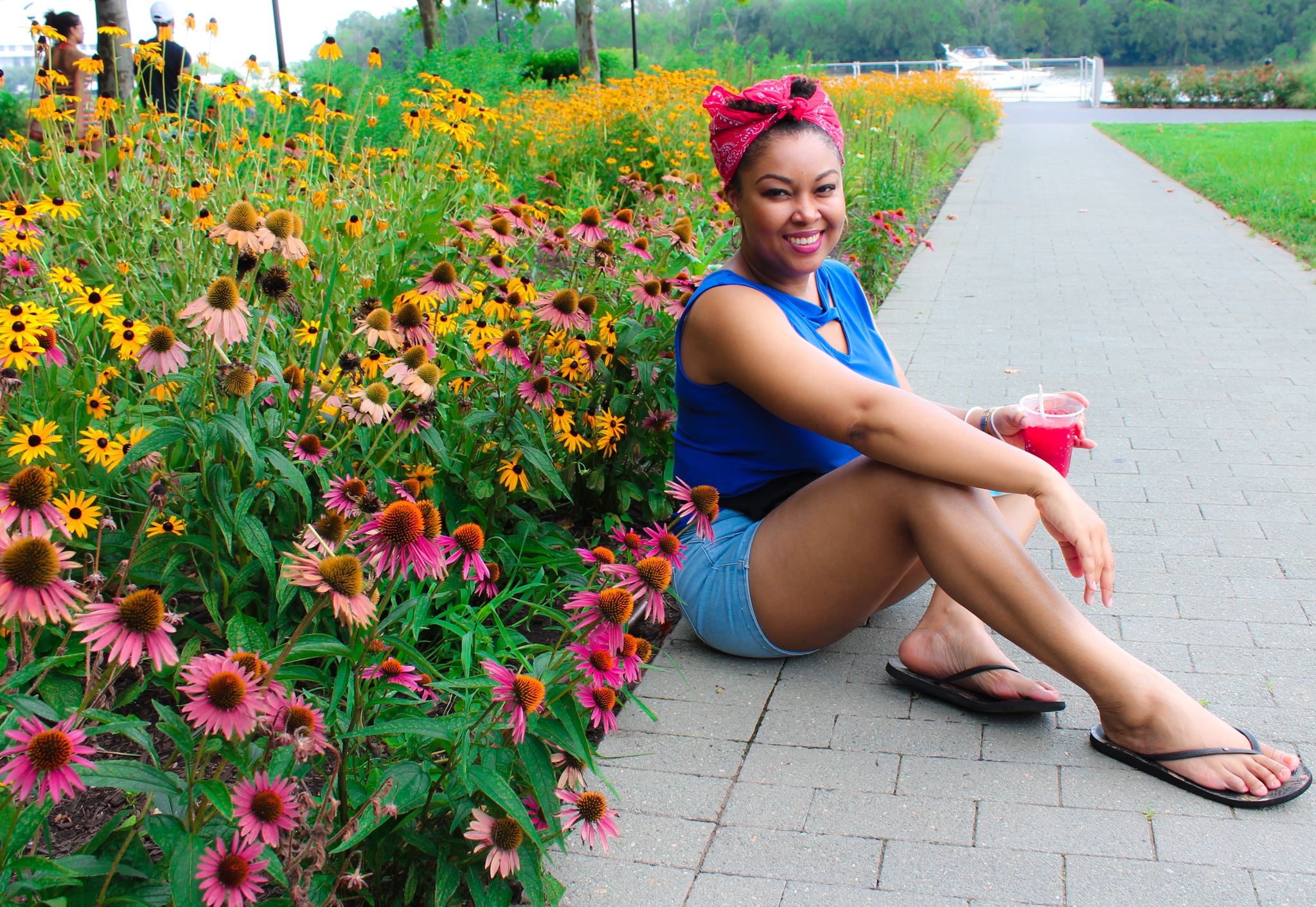 DC blogger Rogan Smith of This Bahamian Gyal sits among flowers in Georgetown, DC