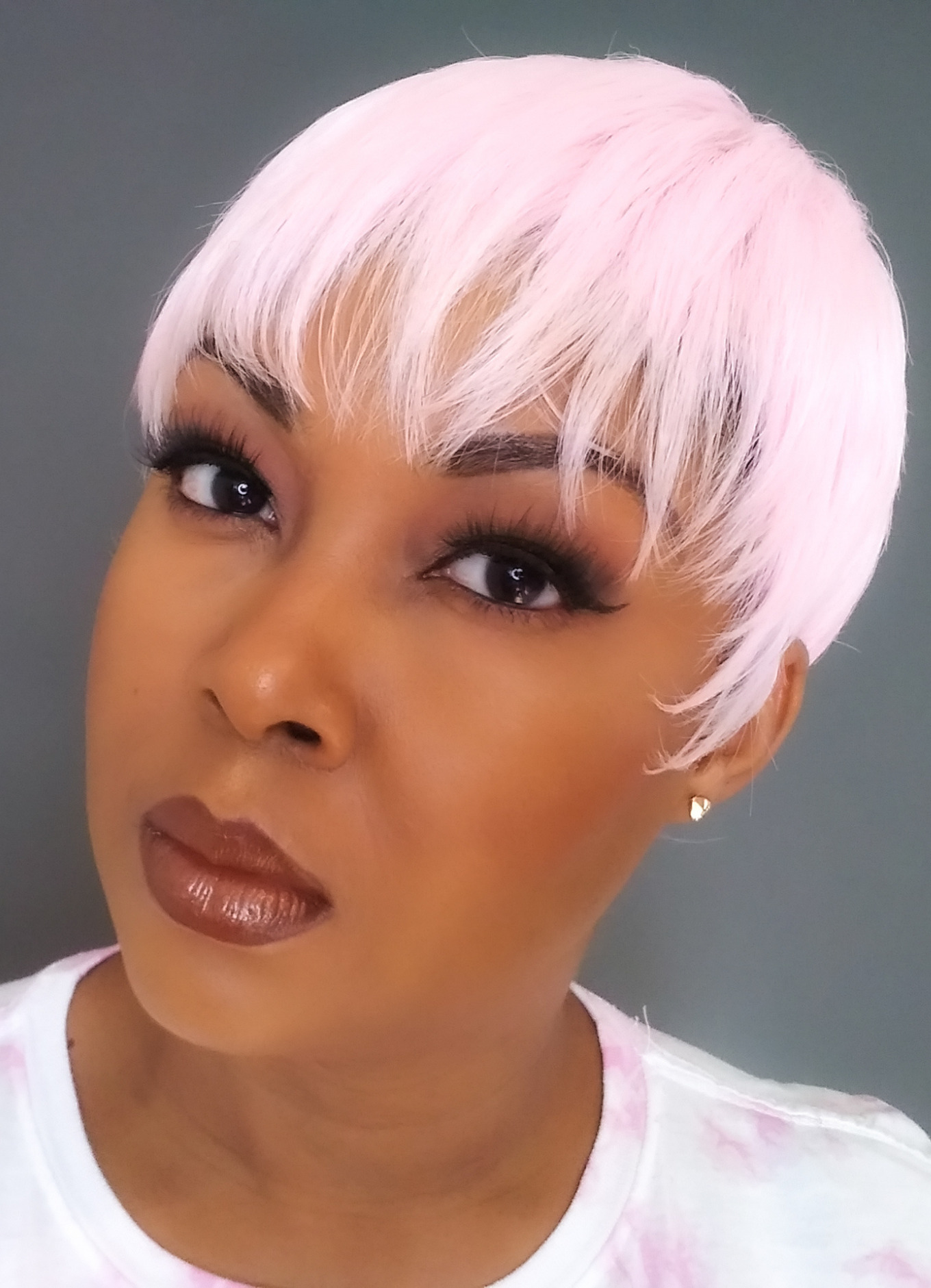 light skinned black woman wearing pink pixie wig