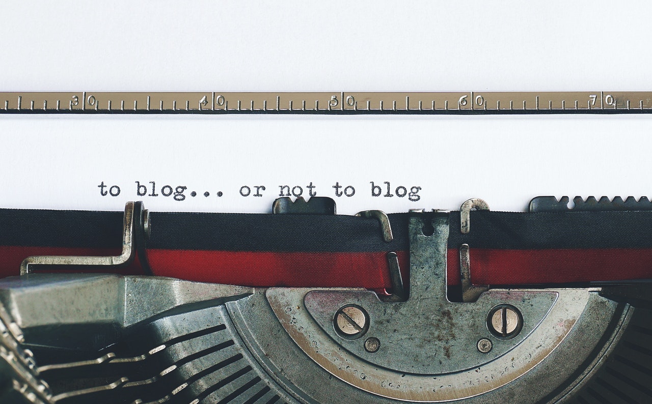 Photo of a typewriter with the words, blog or not to blog written on a white sheet of paper