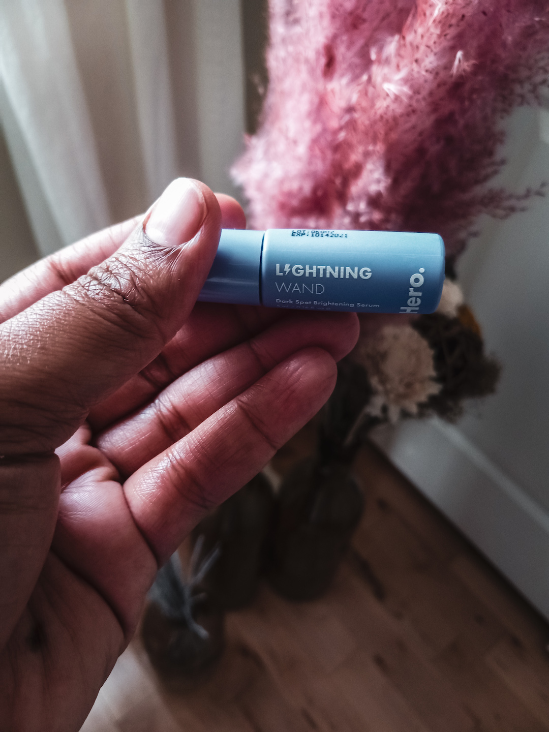 Blogger Rogan Smith holds a small rollerball of Hero's dark spot remover in her hand. The Lightning Wand promises to remove dark spots quickly.