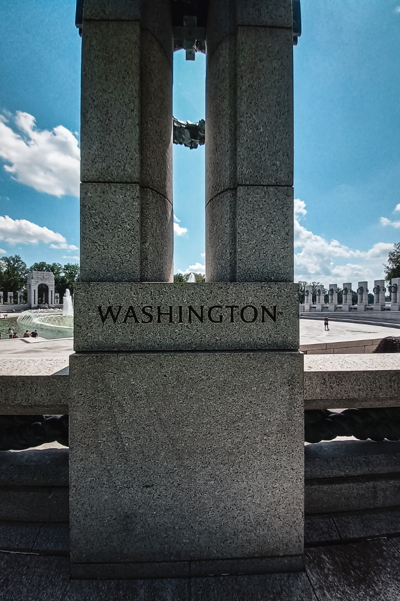 Image of the World War II memorial Washington DC. The word Washington is engraved in stone.