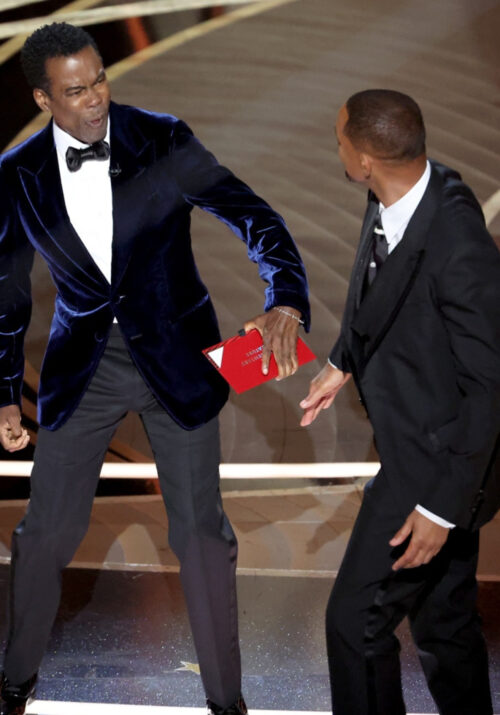 Comedian Chris Rock reacts after being slapped by Oscar nominee, Will Smith.
