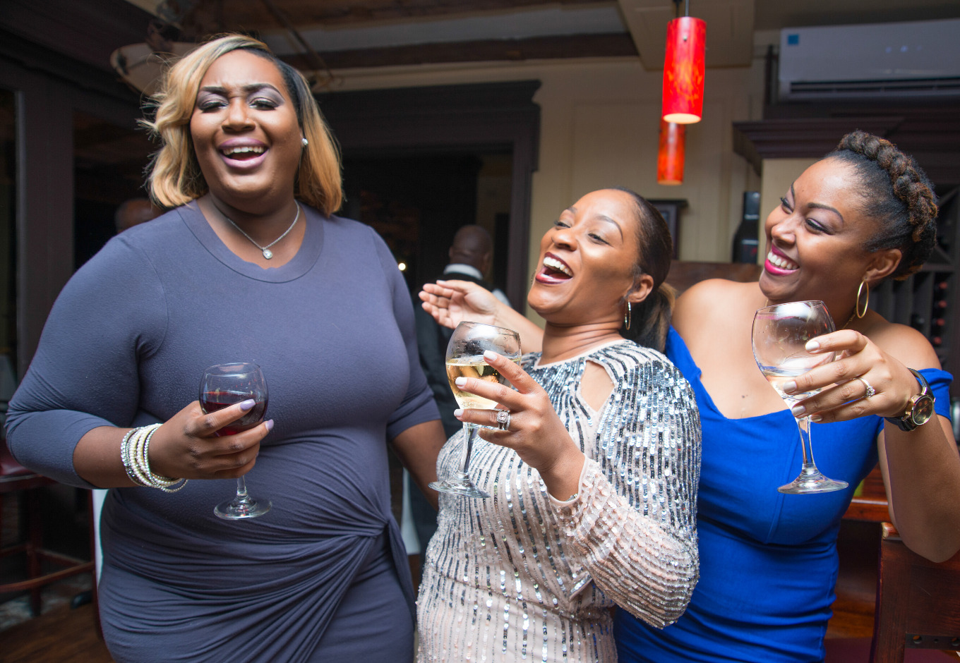 A group of Bahamian women drinking and laughing in a restaurant. Anyone who is dating a Bahamian woman can expect to have a good time.