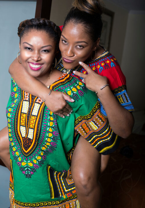 Beautiful Bahamian women smiling and wearing colourful Dashiki shirts