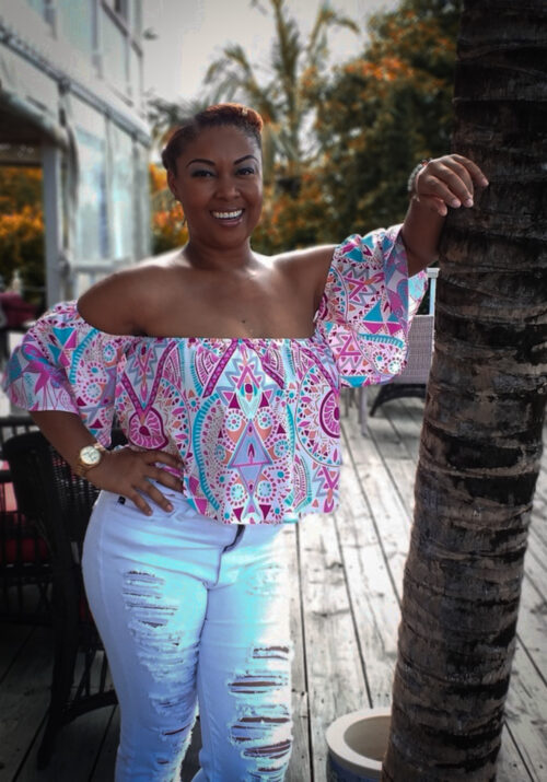 This Bahamian Gyal blogger, Rogan smiles and leans on a coconut tree. She teaches us how to talk like a Bahamian
