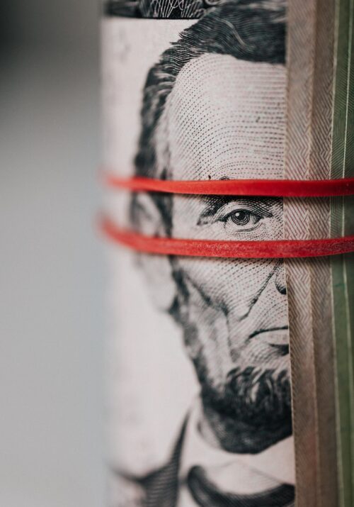 Image shows Abraham Lincoln on the money and it's wrapped around a rubber band