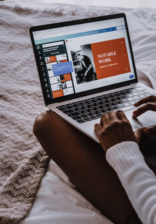 Photo of a black girl sitting on the bed designing a poster in Canva. Photo by Cotton Bro for Pexels