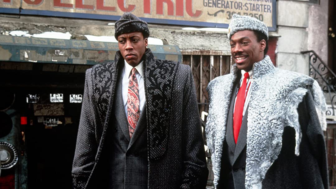 Original still shot from the iconic Coming To America. Arsenio Hall and Eddie Murphy pose in a picture.