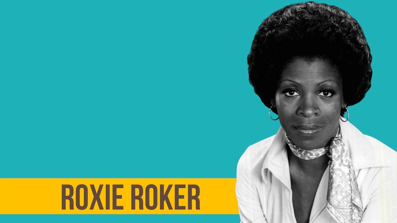 Image of actress Roxie Roker wearing a scarf around her neck and a white shirt.