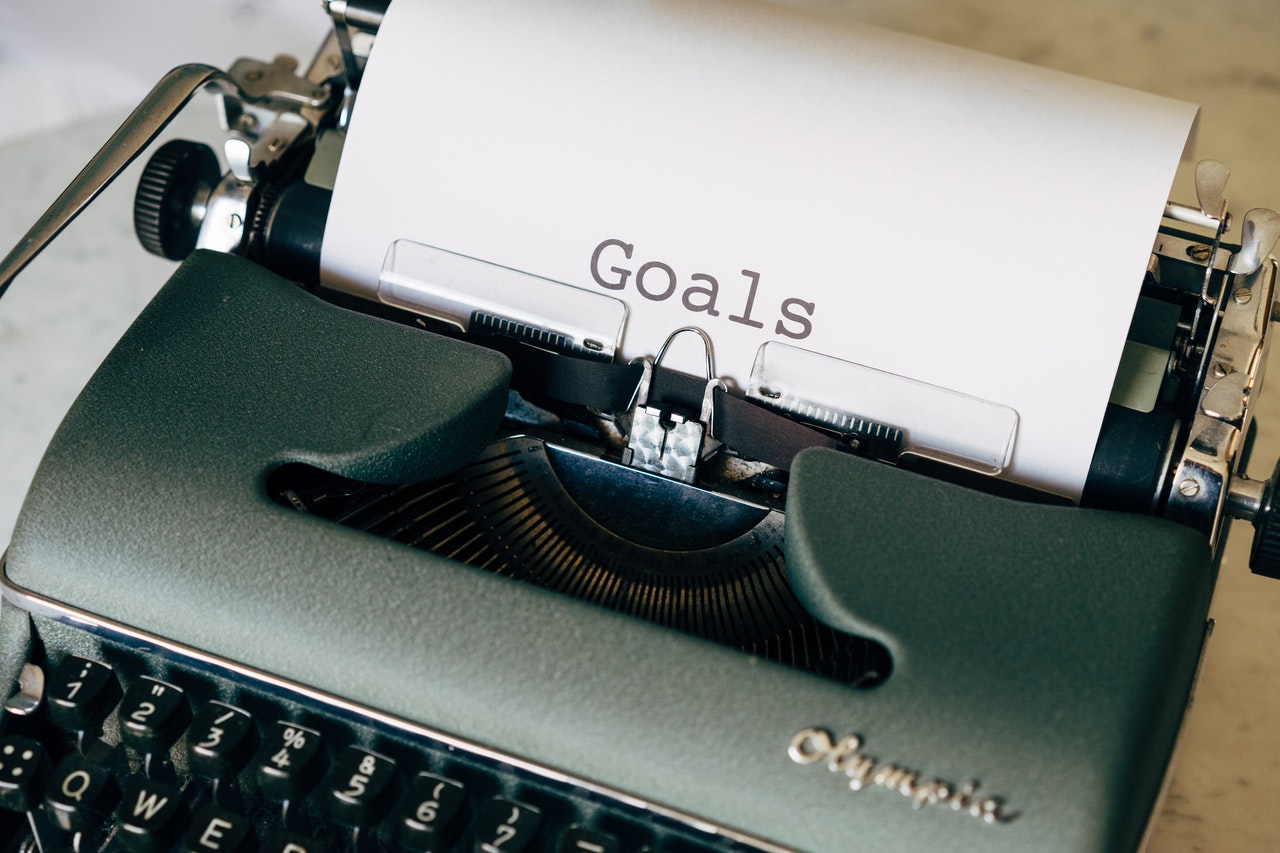 Photo of an old typewriter with the word, goals typed on a sheet of white paper.