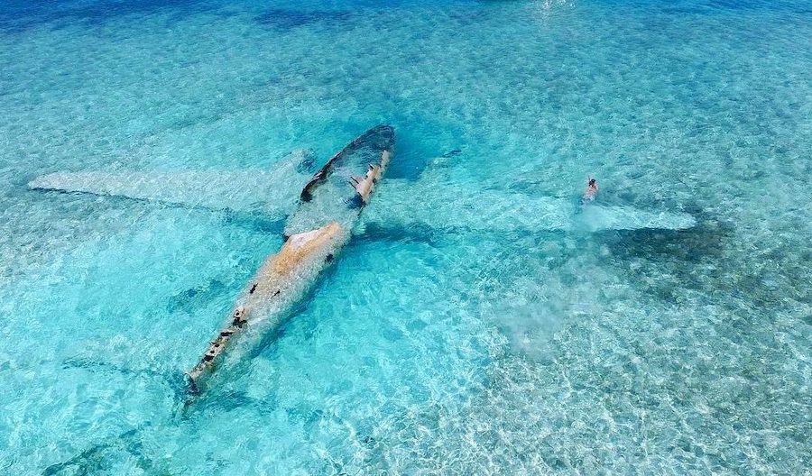A drug plane lies on its belly in shallow waters in Exuma, The Bahamas.