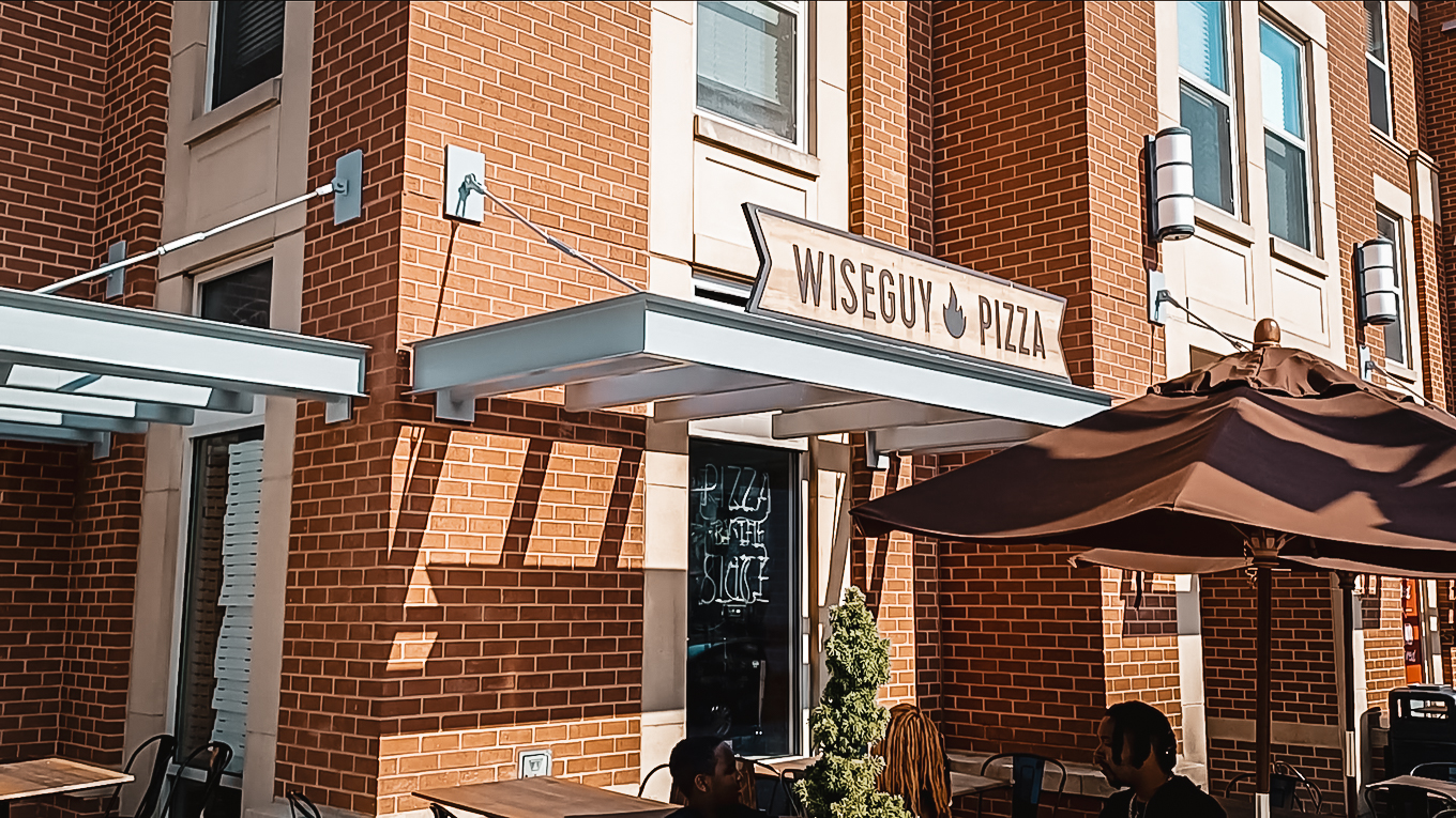 Wiseguy Pizza exterior family sits to eat