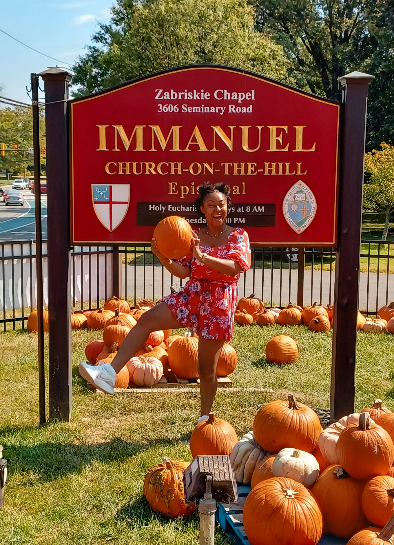 This Bahamian Gyal blogger, Rogan Smith holds a pumpkin in her hand and poses in front of a pumpkin patch in Alexandria, Virginia.