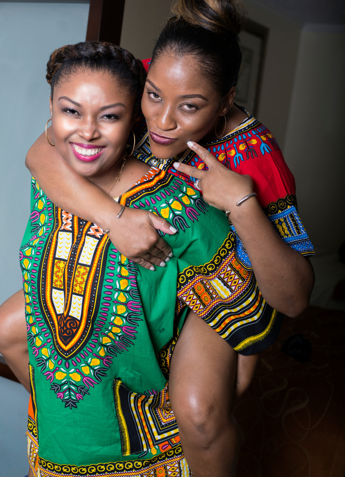 Beautiful Bahamian women smiling and wearing colourful Dashiki shirts. 
