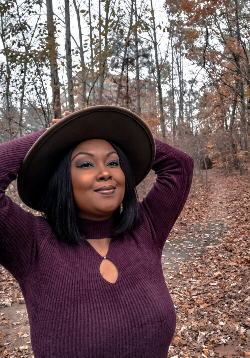 2022 was a year of self-discovery for This Bahamian Gyal blogger, Rogan who smiles and looks off camera in the woods.