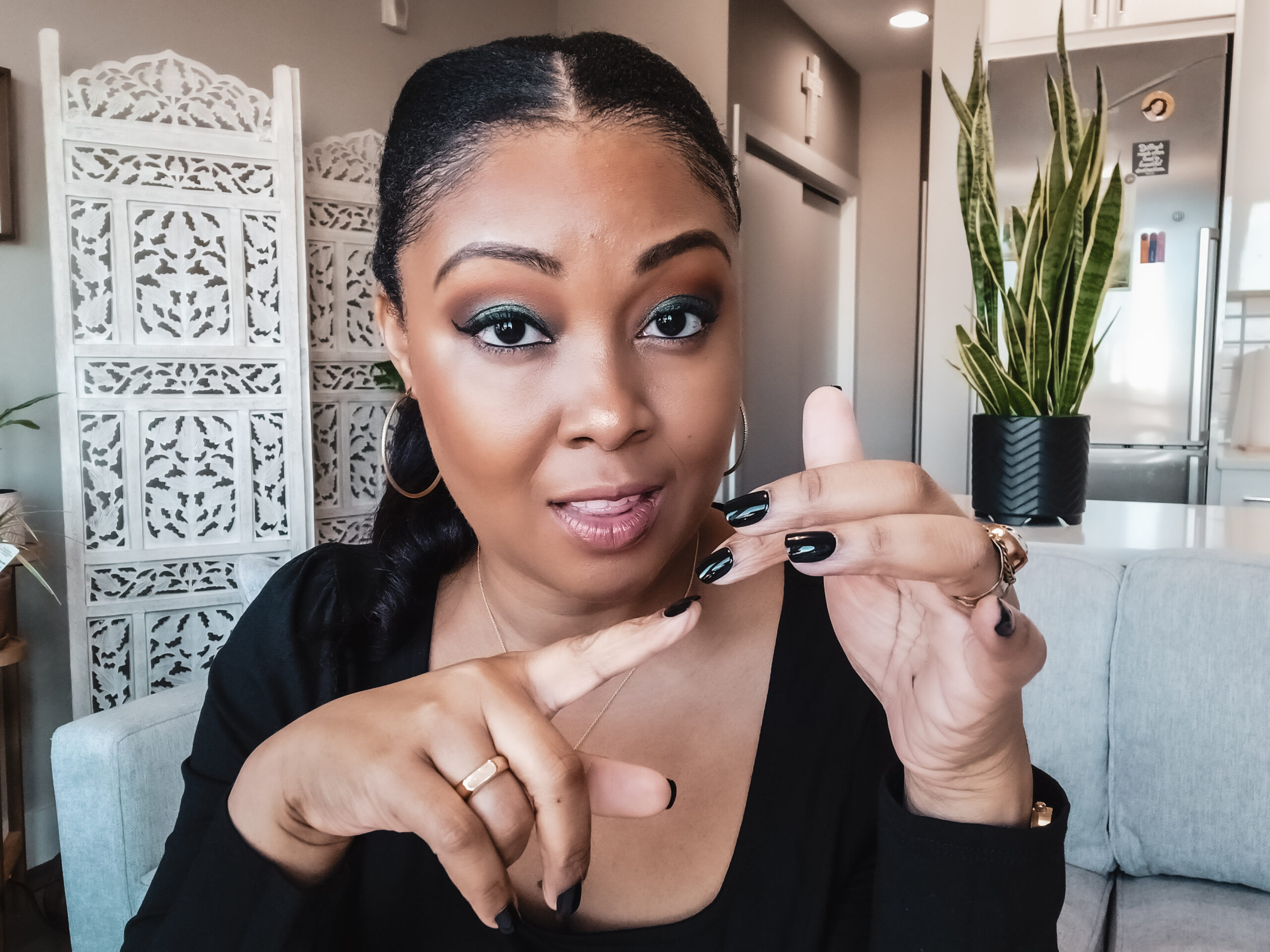 Blogger Rogan counts down the things she did to change her life. She is wearing a black shirt, has her hair in a ponytail and has black manicured nails. She smiles into the camera.