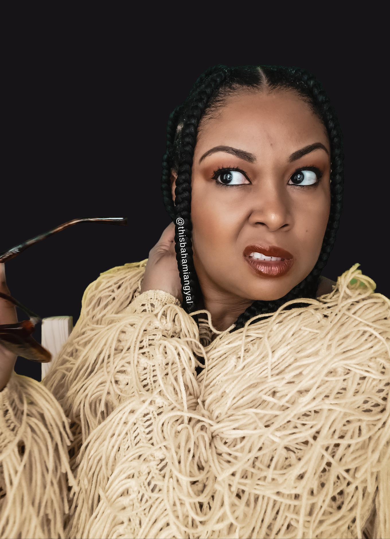 Black woman wears a pained expression on her face as she touches her heavy box braids.