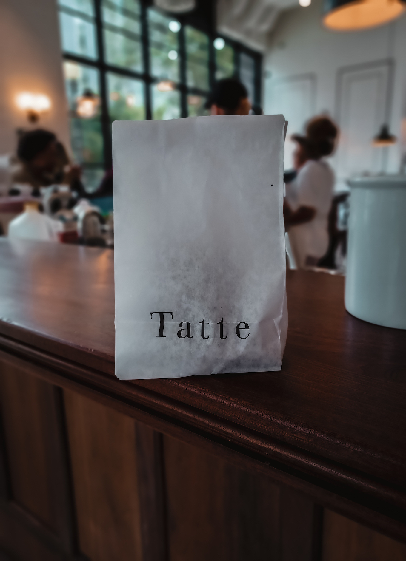 An oatmeal cookie sits inside a white paper bag at Tatte Bakery.
