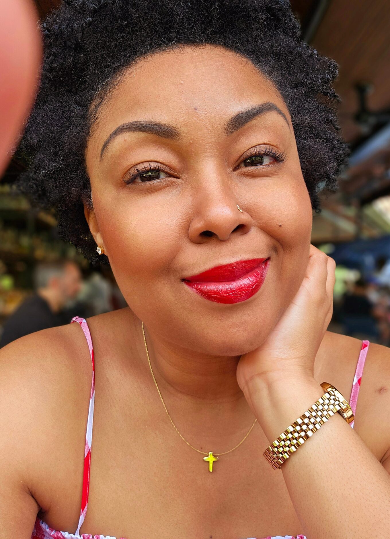 Photo of a This Bahamian Gyal blogger, Rogan. She is wearing a red and white stripy dress and smiles for the camera wearing red lipstick. Her black hair is styled in a curly afro.