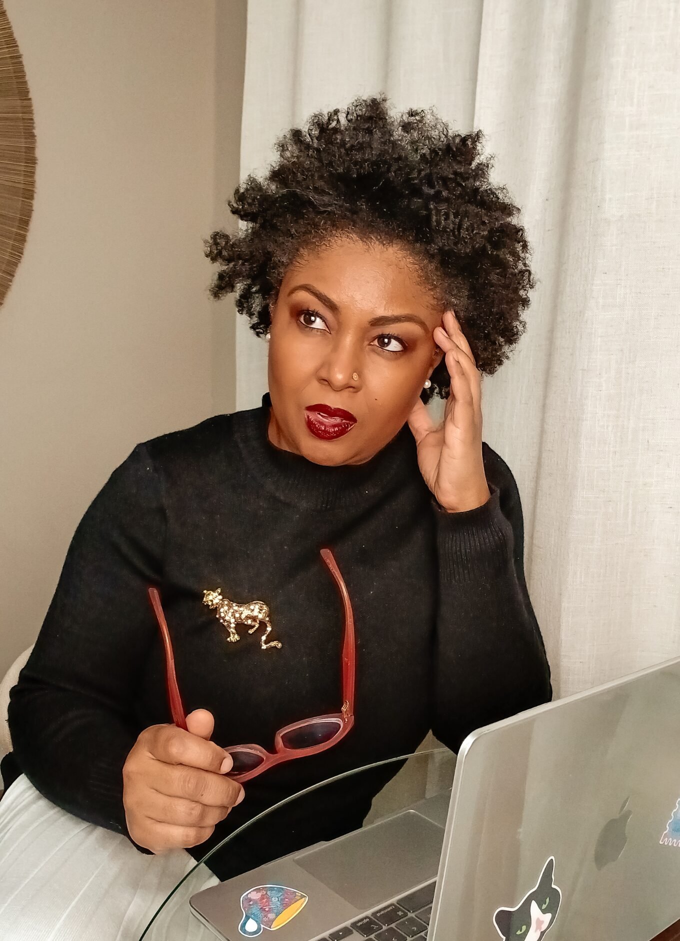 DC based blogger, Rogan of This Bahamian Gyal poses in front of her Apple laptop with her glasses in hand