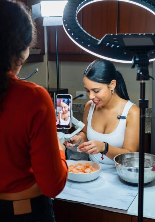 How to find your YouTube niche. Two women record food tutorials in the kitchen with ring lights